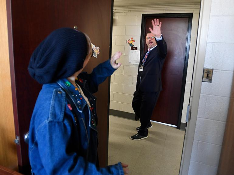 President Taylor waves to a student inside of Shiple Hall on move-in day.